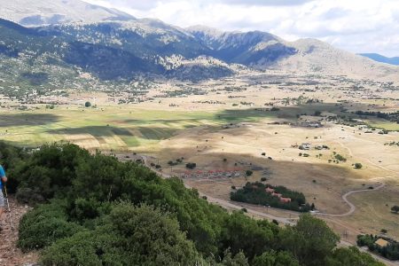 Πεζοπόρος κατεβαίνει μονοπάτι με θέα στο Λιβάδι Παρνασσού