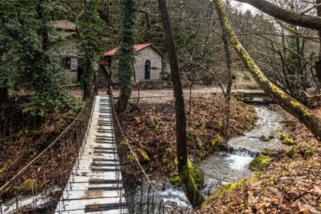Ξύλινο ντεκ με πολύχρωμες ξαπλώστρες δίπλα σε ρυάκι του δάσους